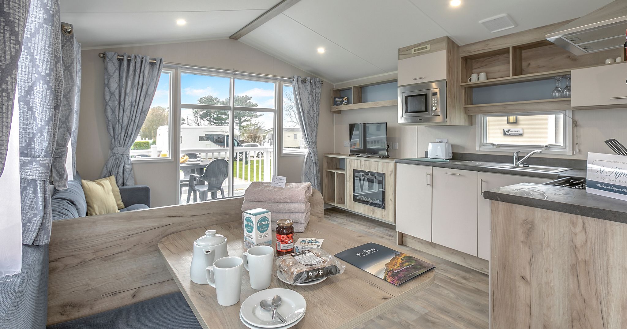 Modern holiday caravan interior with open kitchen, dining area, and living space