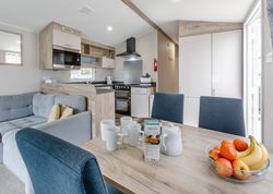 Modern kitchen and dining area in a cozy home with a bowl of fruit on the table.