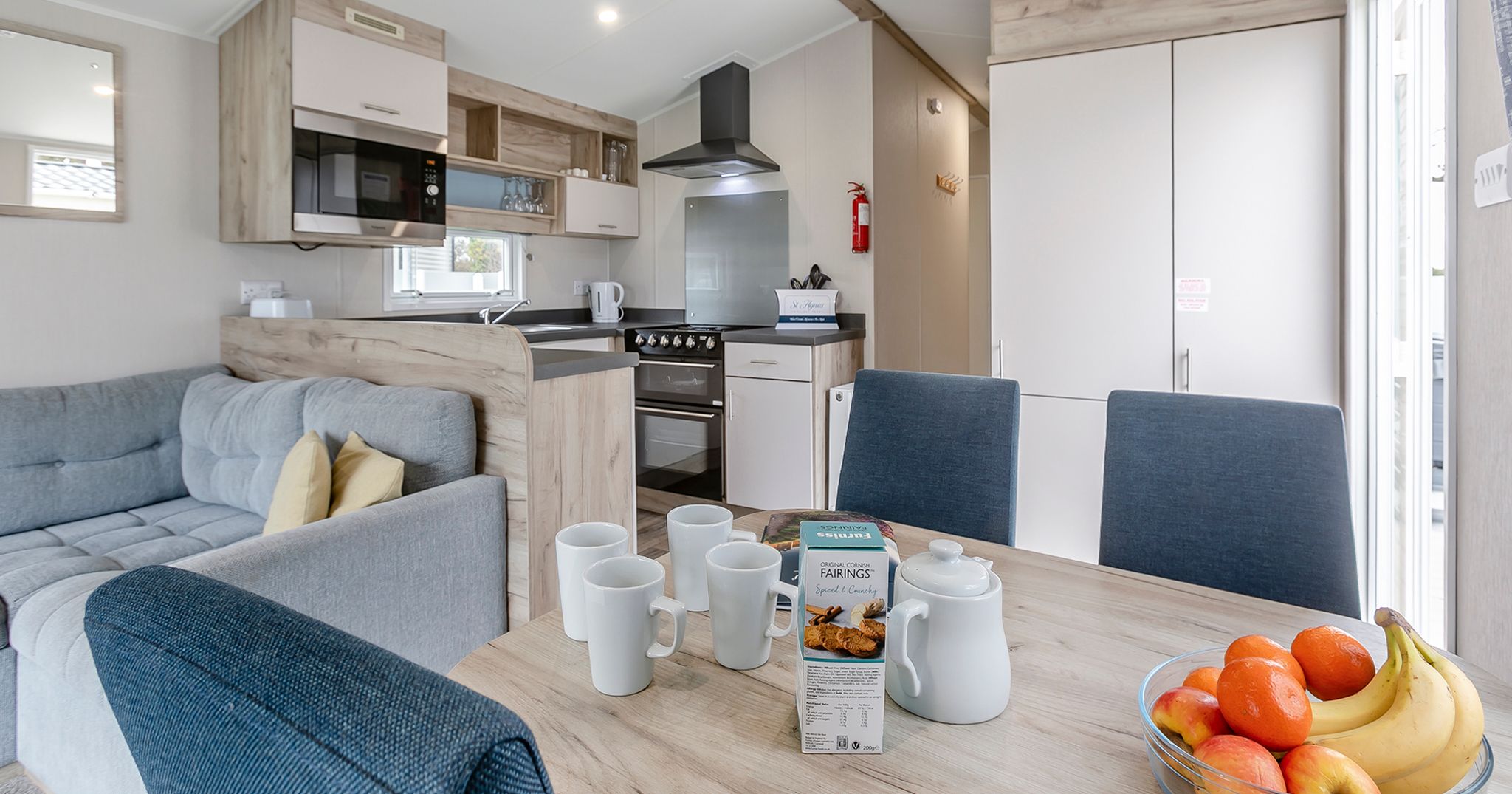 Modern kitchen and dining area in a cozy home with a bowl of fruit on the table.