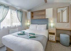 Modern bedroom with double bed, light blue accents, and contemporary furnishings