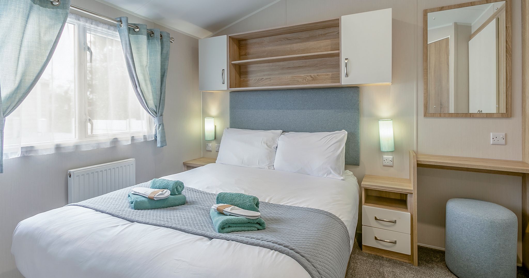 Modern bedroom with double bed, light blue accents, and contemporary furnishings