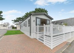 Modern holiday park static caravan with white deck and railing