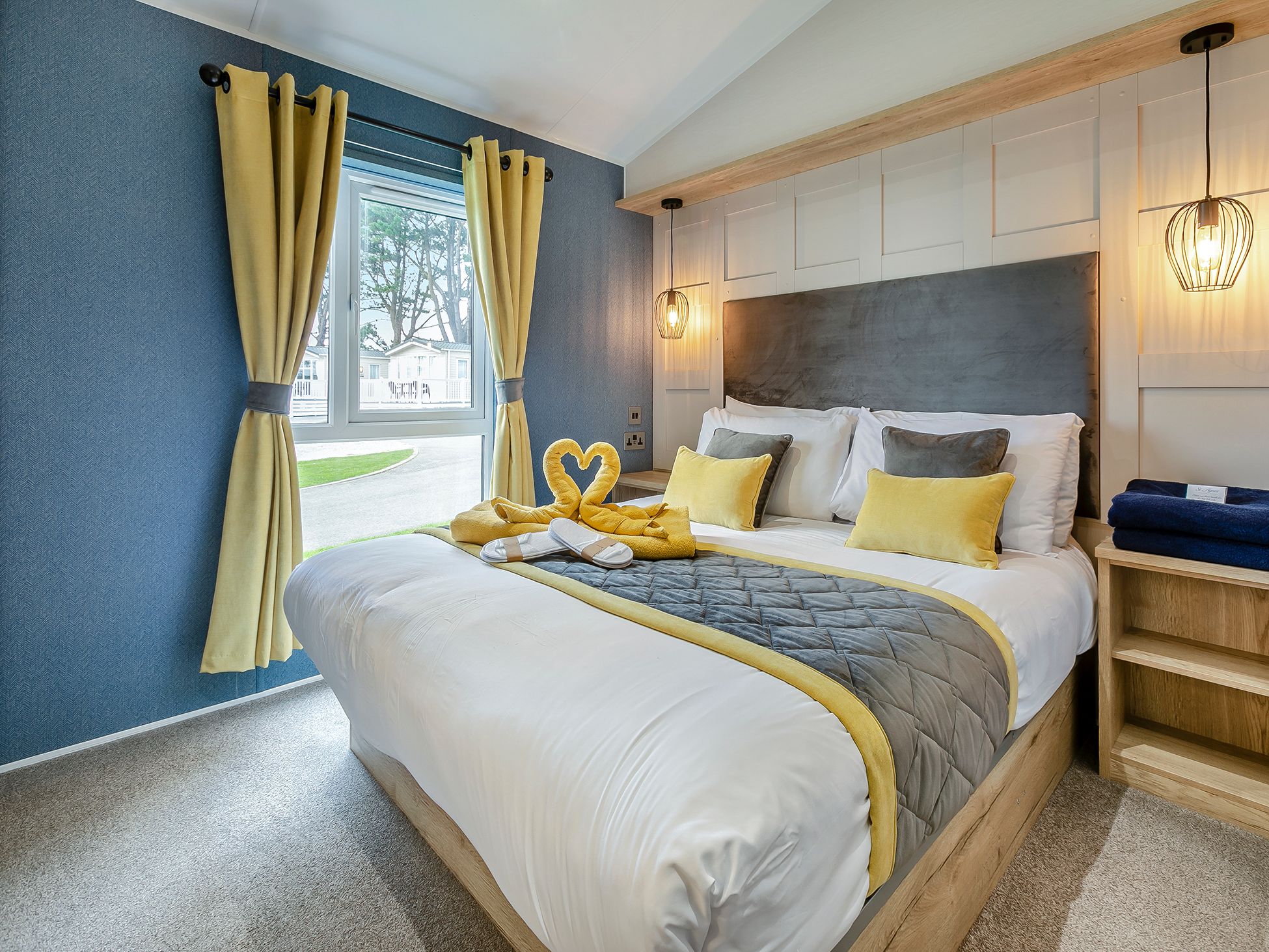 Modern bedroom with a large bed, yellow curtains, and stylish lighting