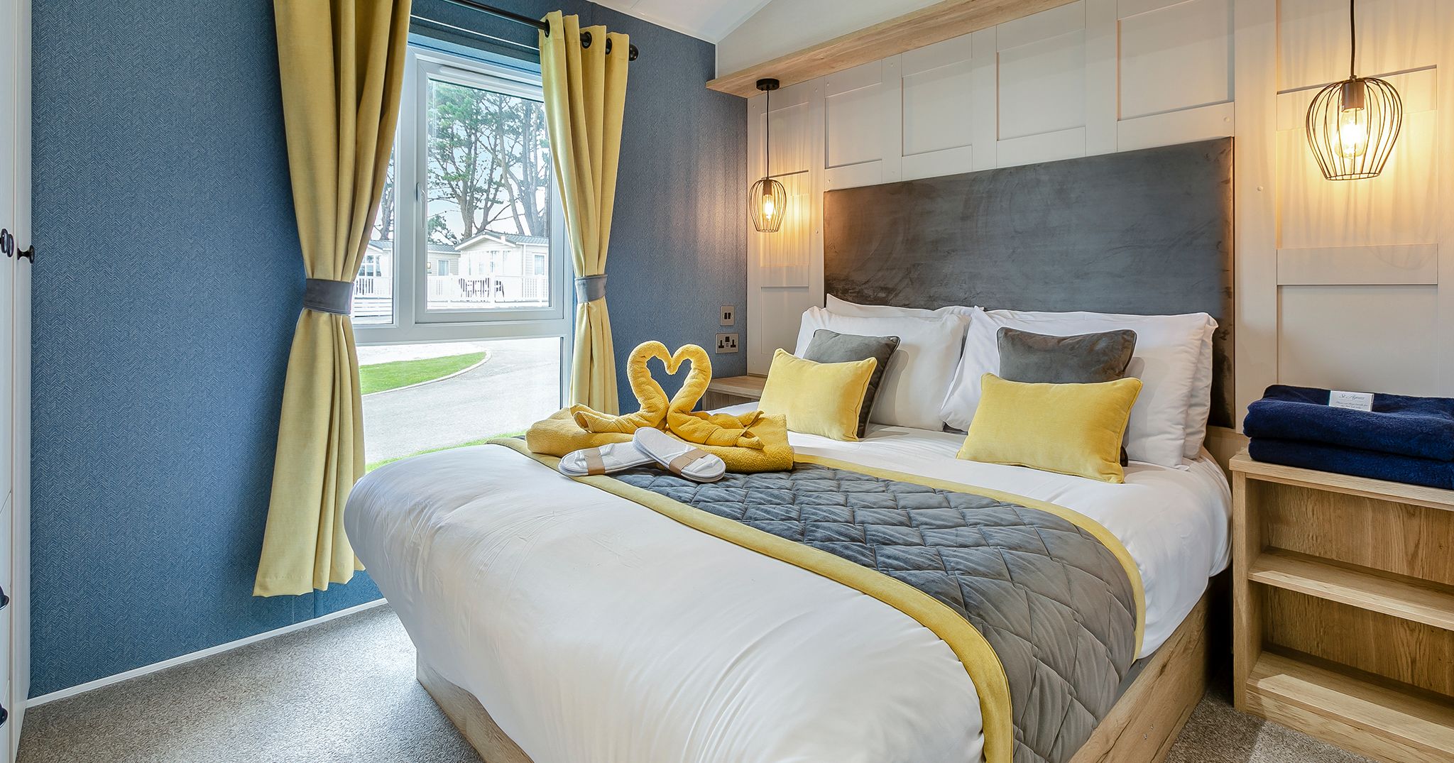 Modern bedroom with a large bed, yellow curtains, and stylish lighting