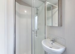 Modern bathroom with glass shower enclosure and white sink