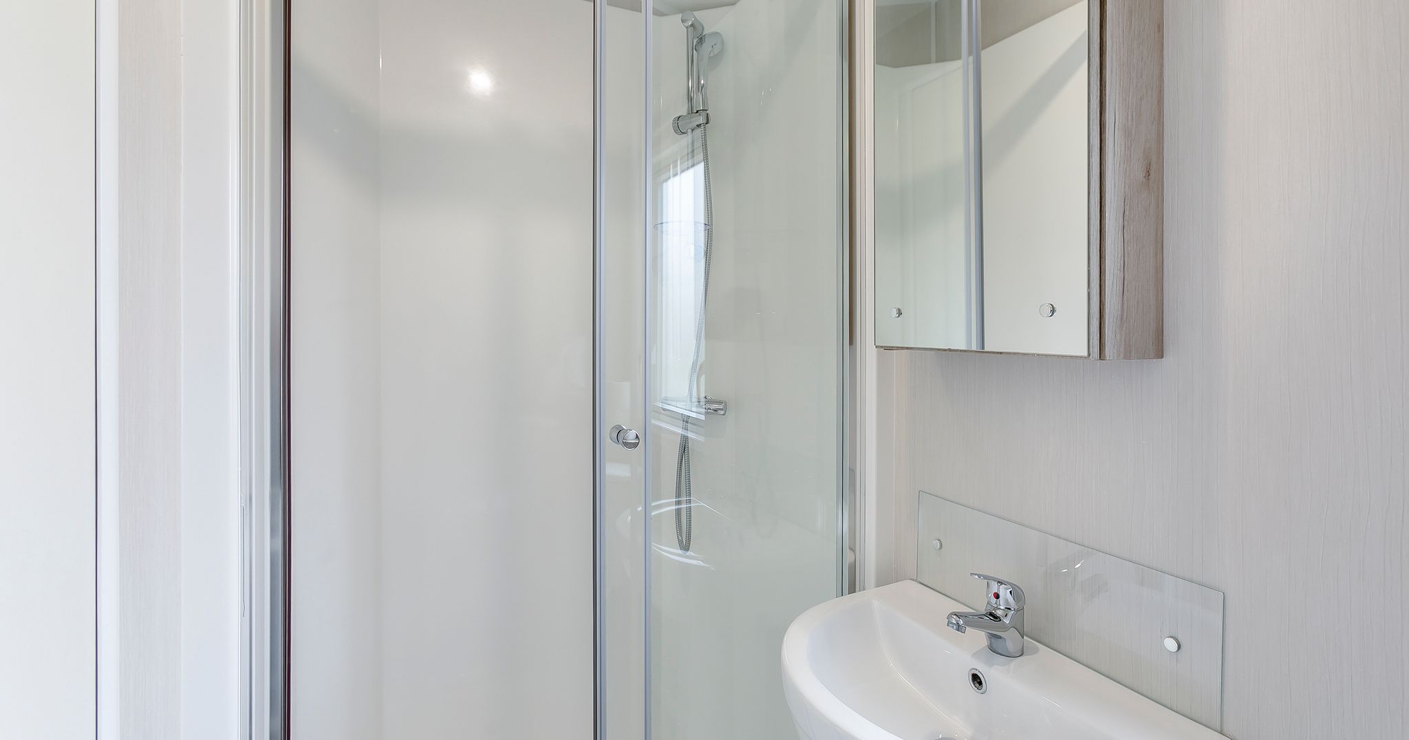 Modern bathroom with glass shower enclosure and white sink