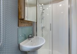 Modern bathroom with sink, mirror cabinet, and glass shower enclosure