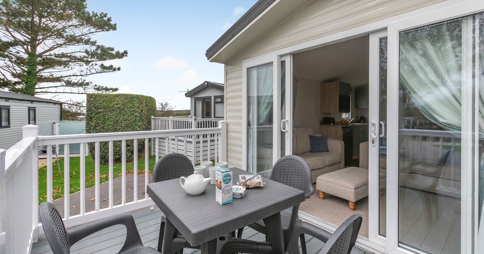 Deck area outside a modern static caravan with table and chairs