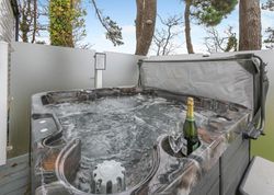 Outdoor hot tub with bubbling water, a bottle of champagne, and a glass