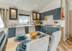Modern kitchen and dining area with navy cabinets and a set dining table