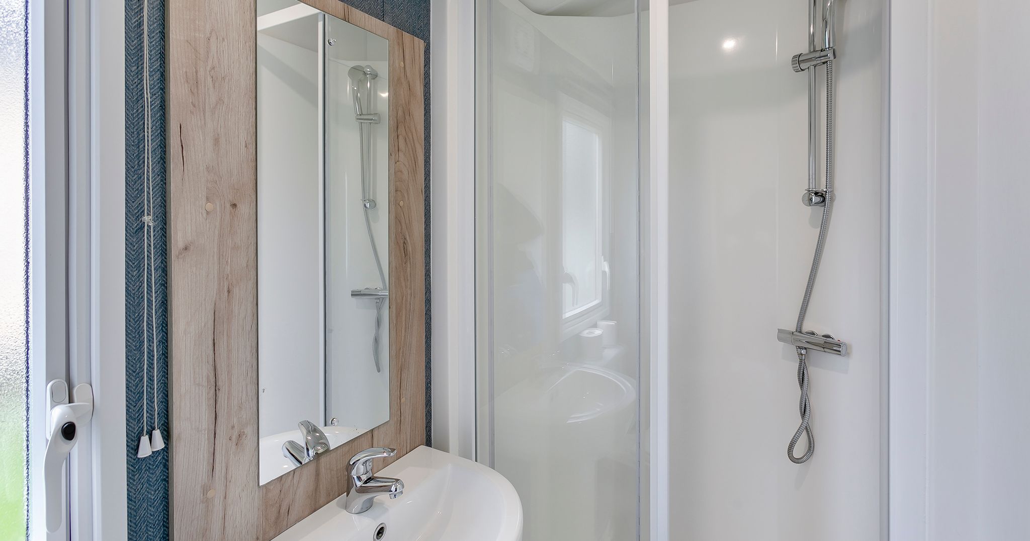 Modern bathroom with a corner shower, sink, and mirror