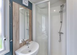 Modern bathroom with a corner shower, sink, and mirror