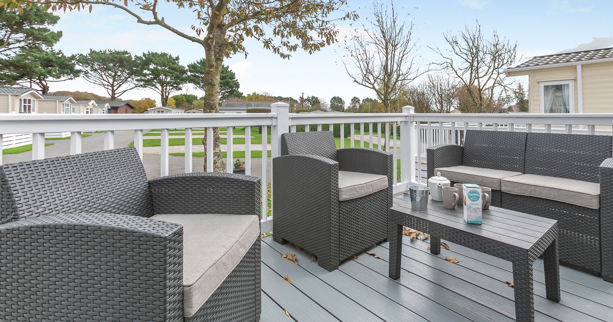 Outdoor patio with grey wicker furniture and a coffee table on a deck