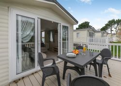 Outdoor patio of a mobile home with table and chairs set for a meal