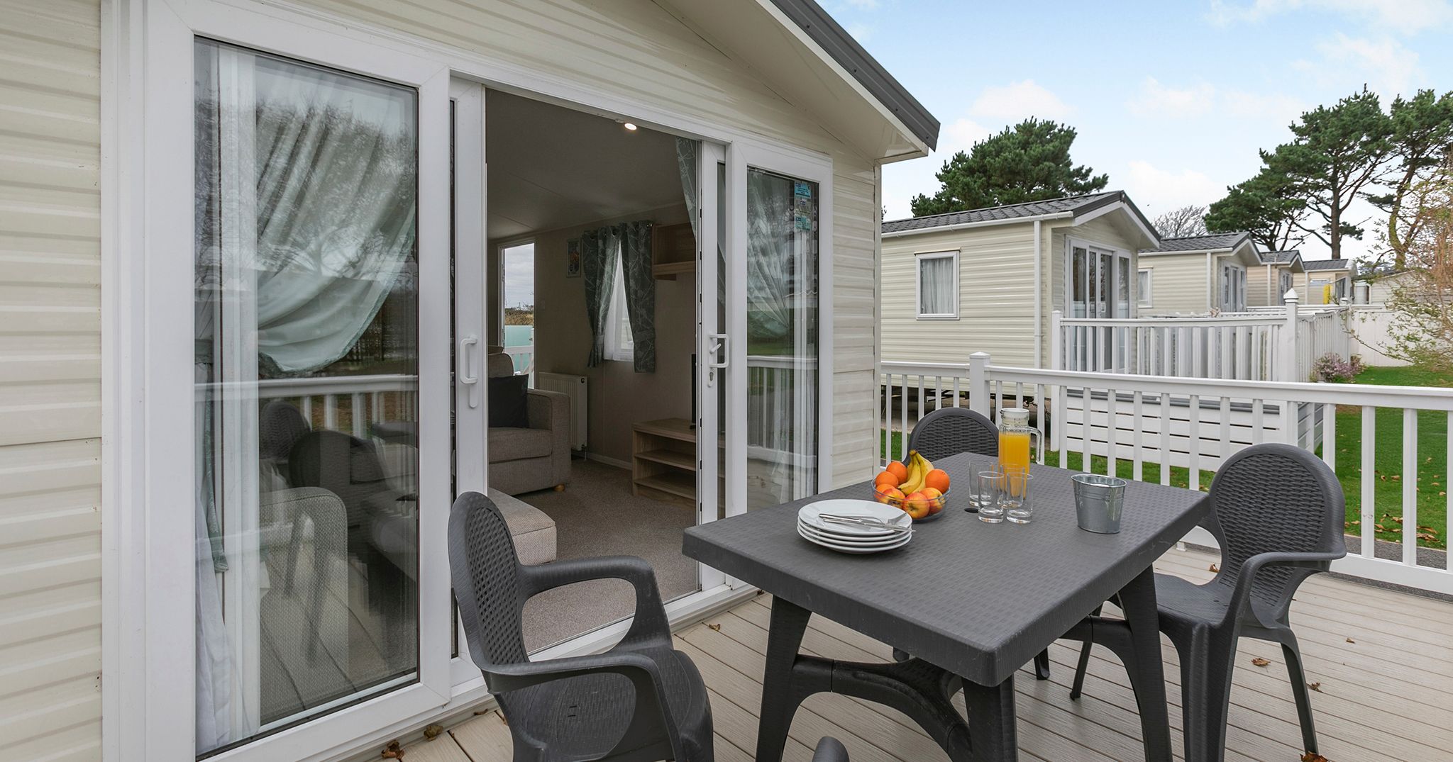 Outdoor patio of a mobile home with table and chairs set for a meal