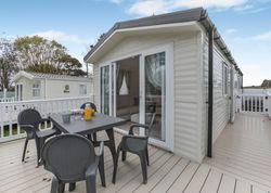 Modern holiday caravan with outdoor seating area on wooden deck
