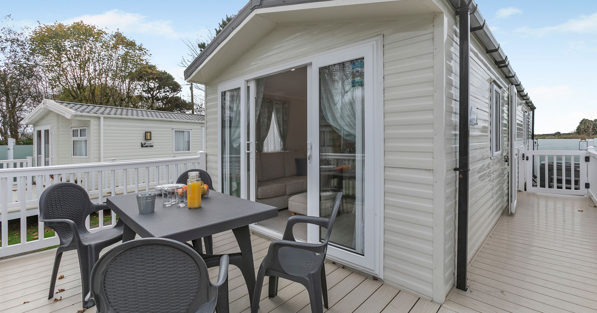 Modern holiday caravan with outdoor seating area on wooden deck