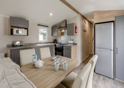 Modern kitchen and dining area in a compact living space with table set for tea