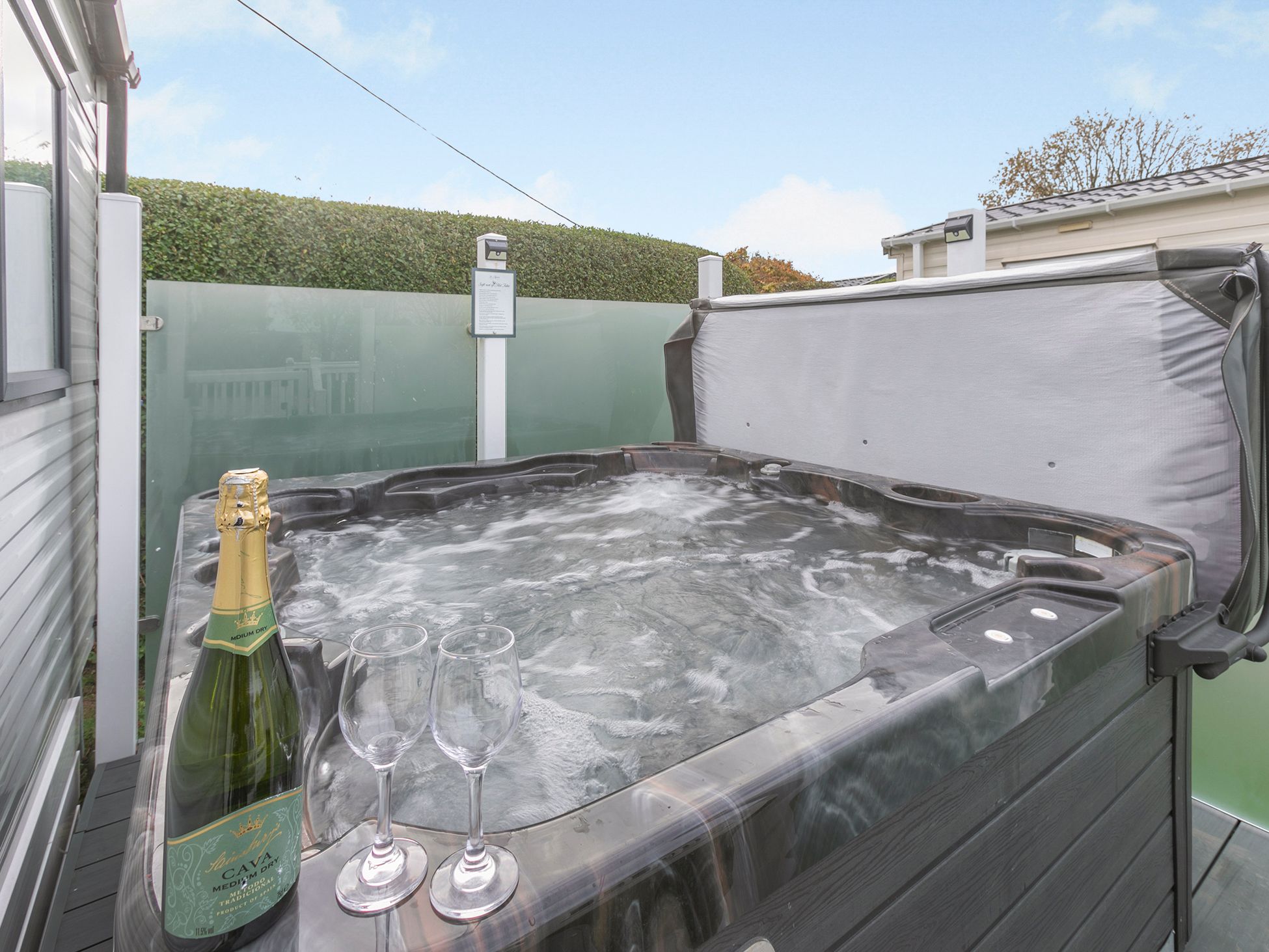 Outdoor hot tub with champagne and glasses on the edge