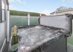 Outdoor hot tub with champagne and glasses on the edge