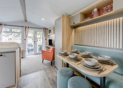 Modern and cozy mobile home interior with a kitchen, dining area, and living space.