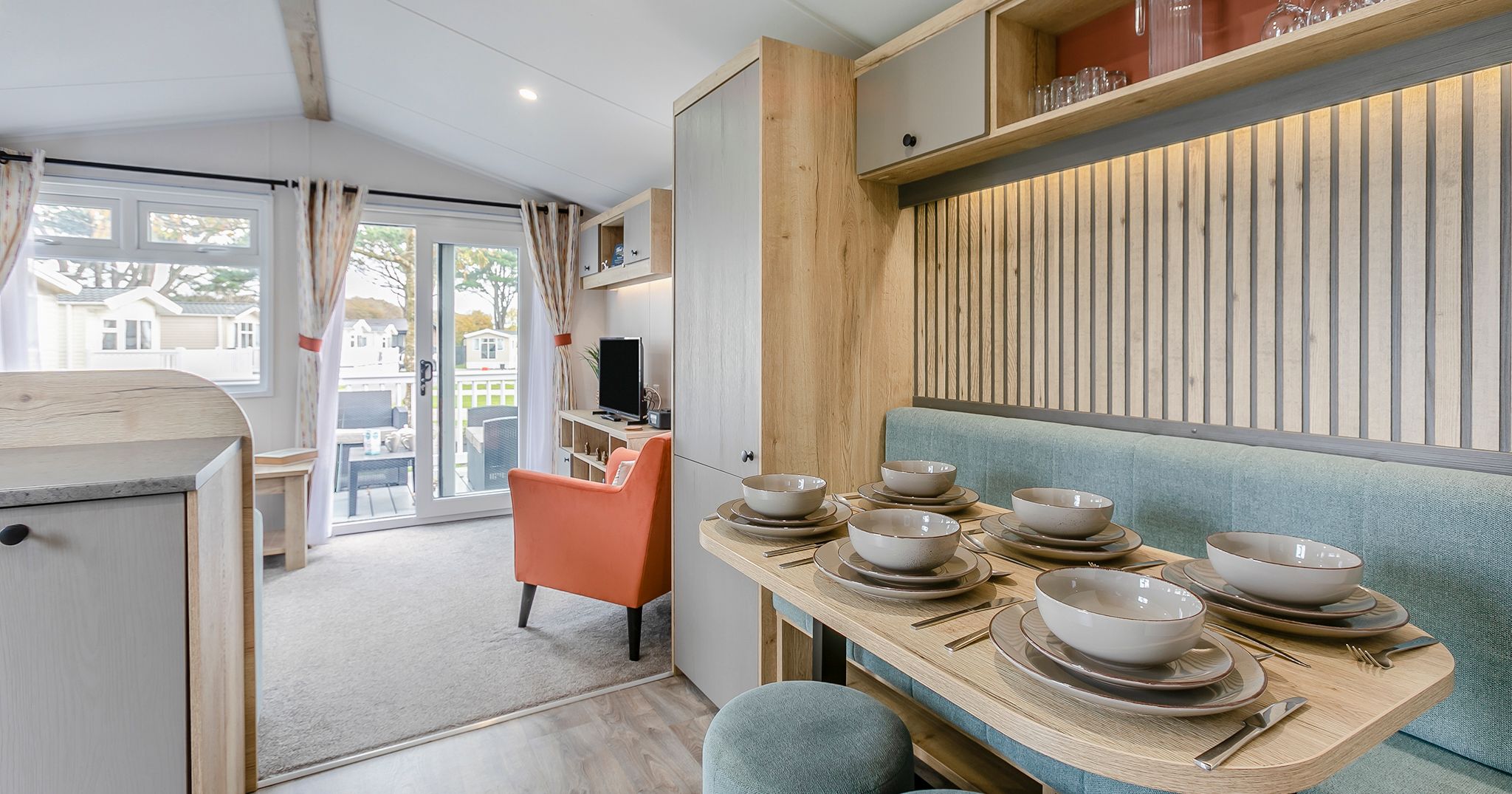 Modern and cozy mobile home interior with a kitchen, dining area, and living space.