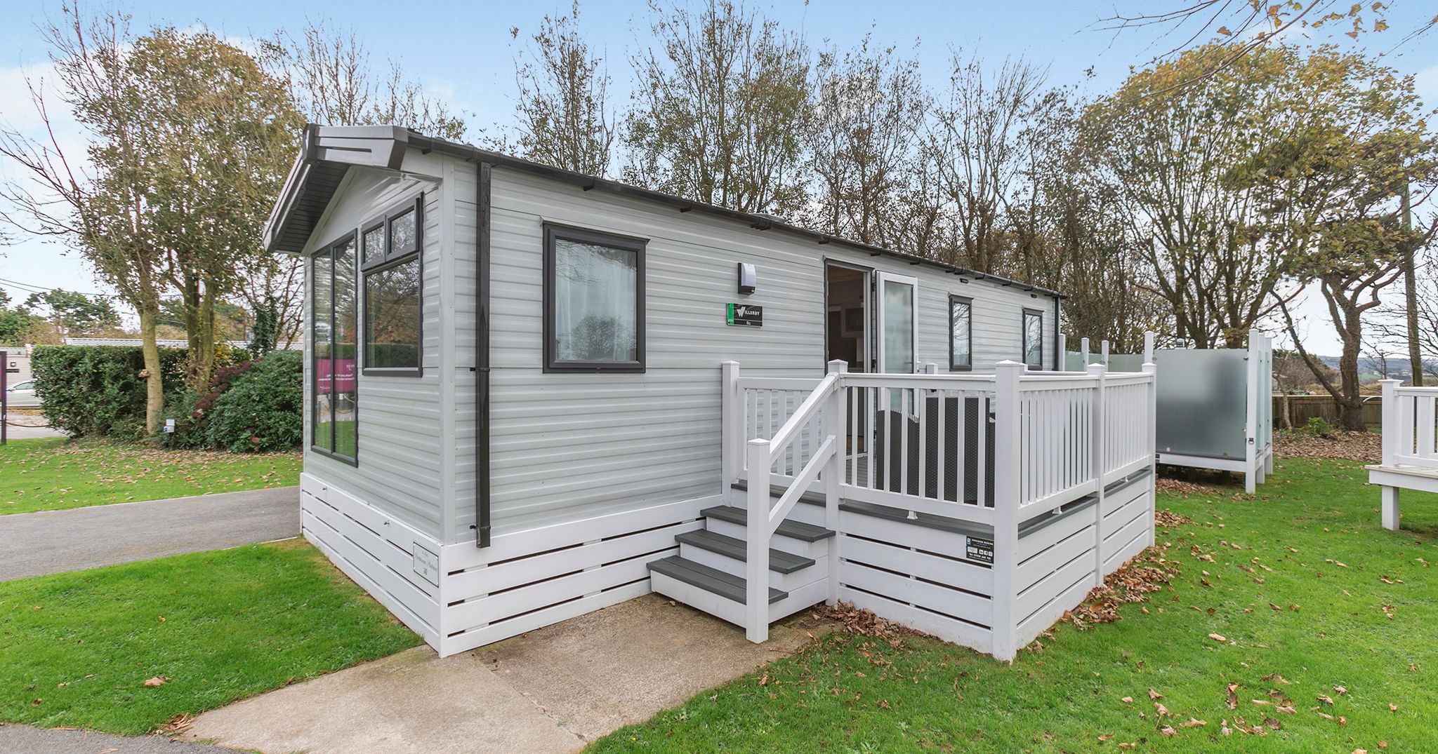 Modern mobile home with gray siding and white railing