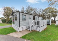 Modern mobile home with gray siding and white railing