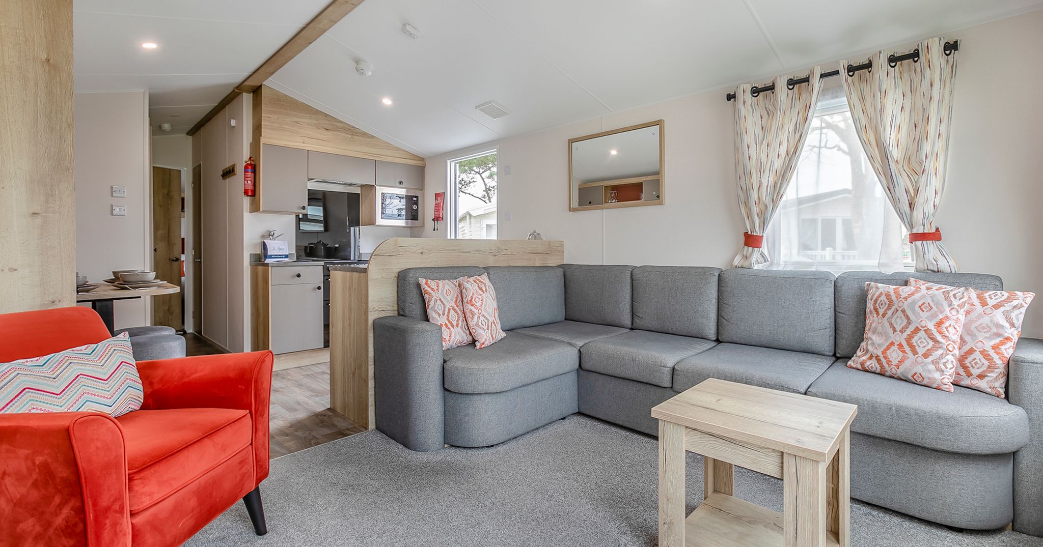 Modern living room with gray sectional sofa and red armchair