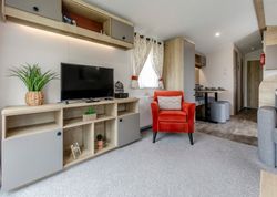 Modern living room with red armchair, TV, and wood furnishings