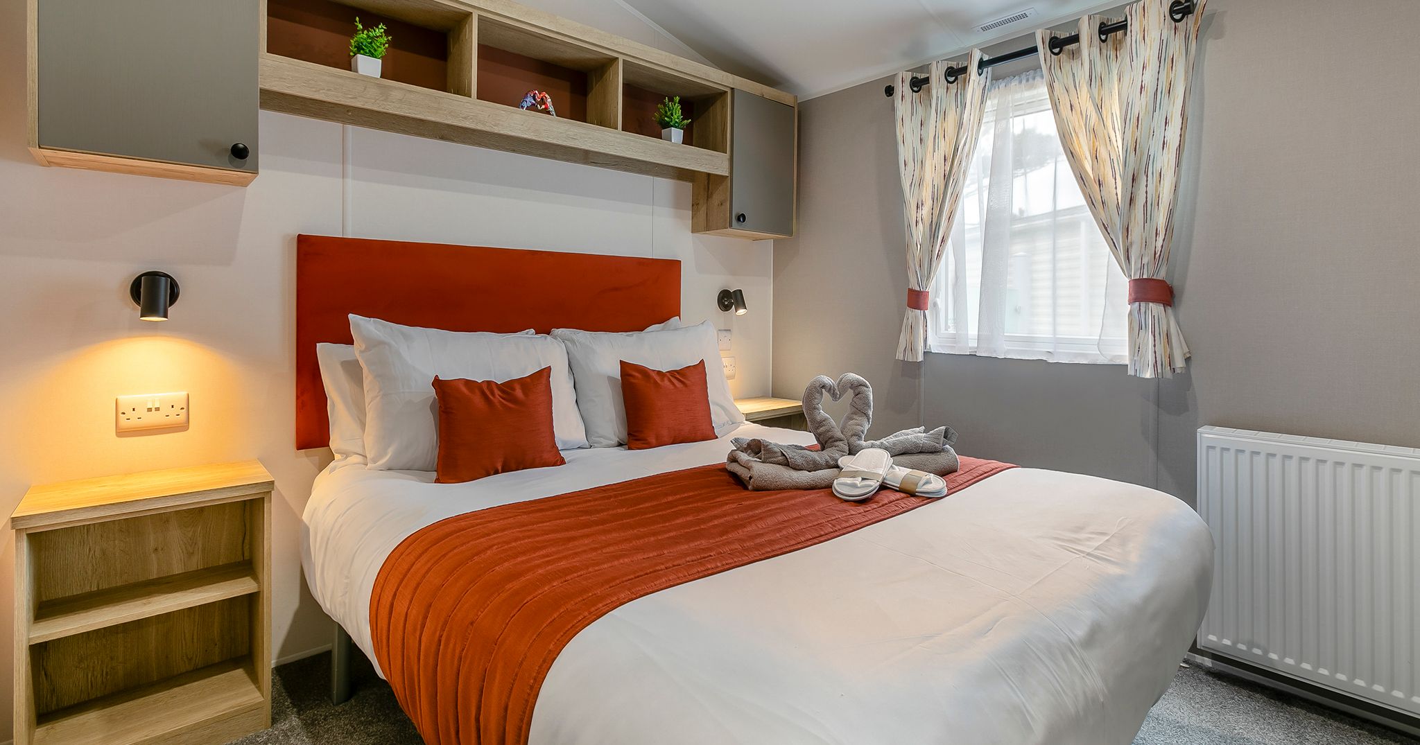 Modern bedroom with orange accents and neatly made bed
