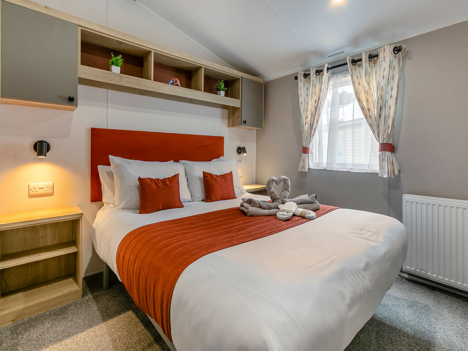 Modern bedroom with orange accents and neatly made bed