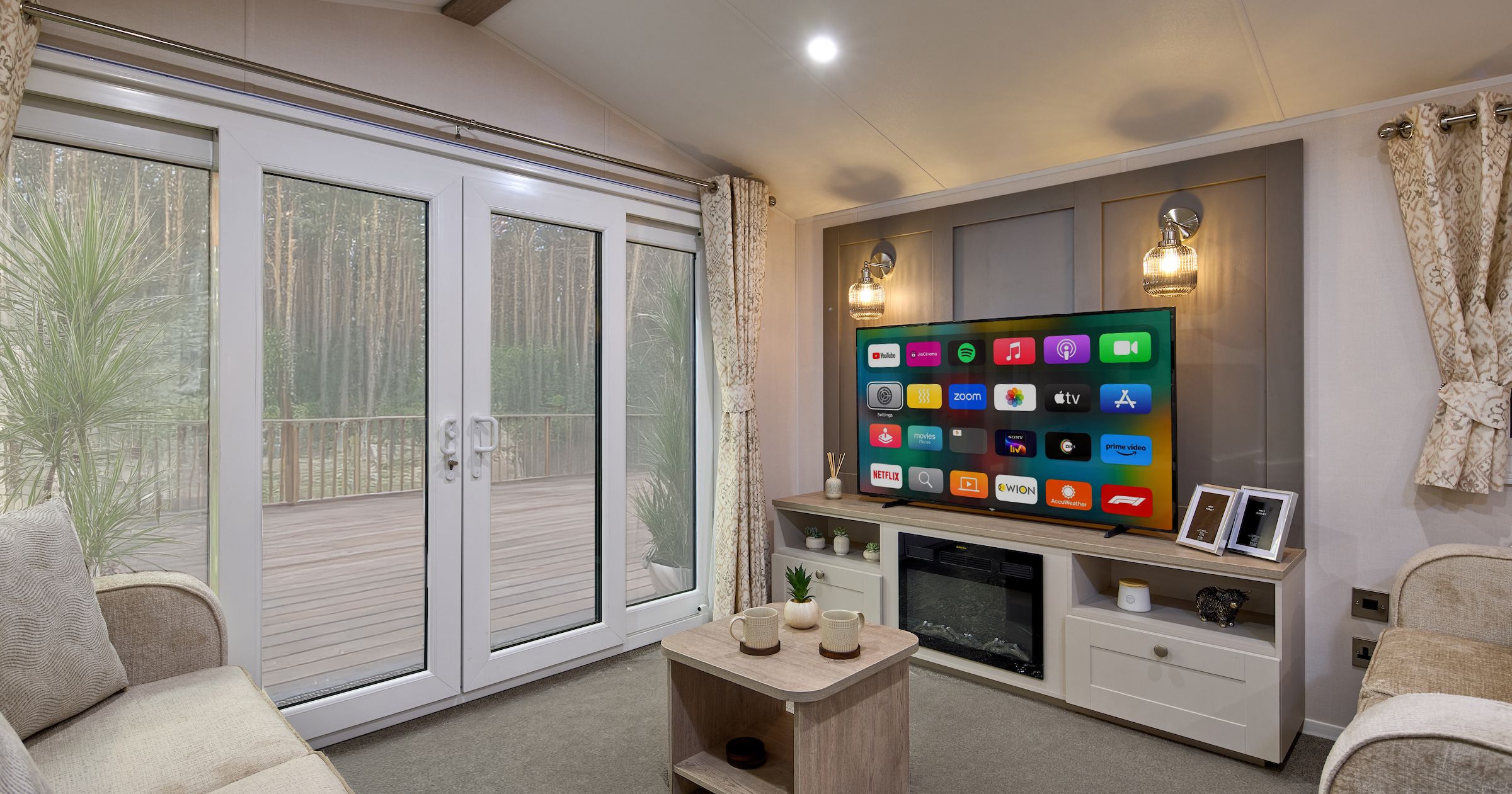 Modern living room with large windows, TV, and cozy seating