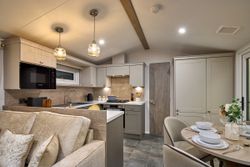 Modern kitchen and dining area with neutral tones and cozy lighting.