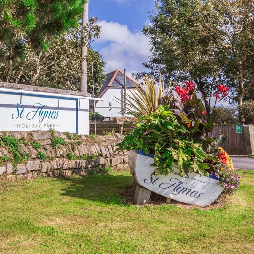 St Agnes Holiday Park entrance sign with flower planter