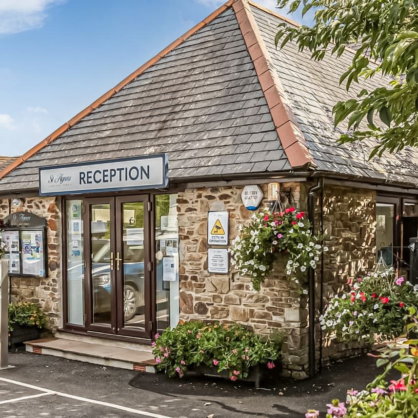 Reception building with stone walls, flower baskets, and signage
