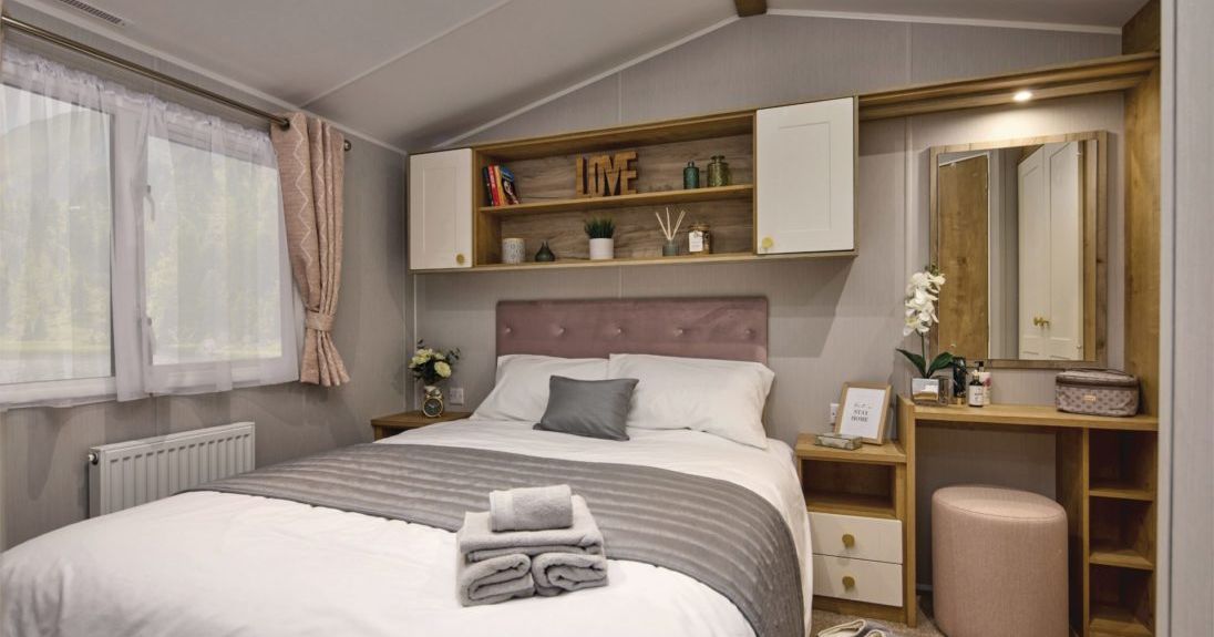 Cozy modern bedroom with double bed, dressing table, and decorative shelves