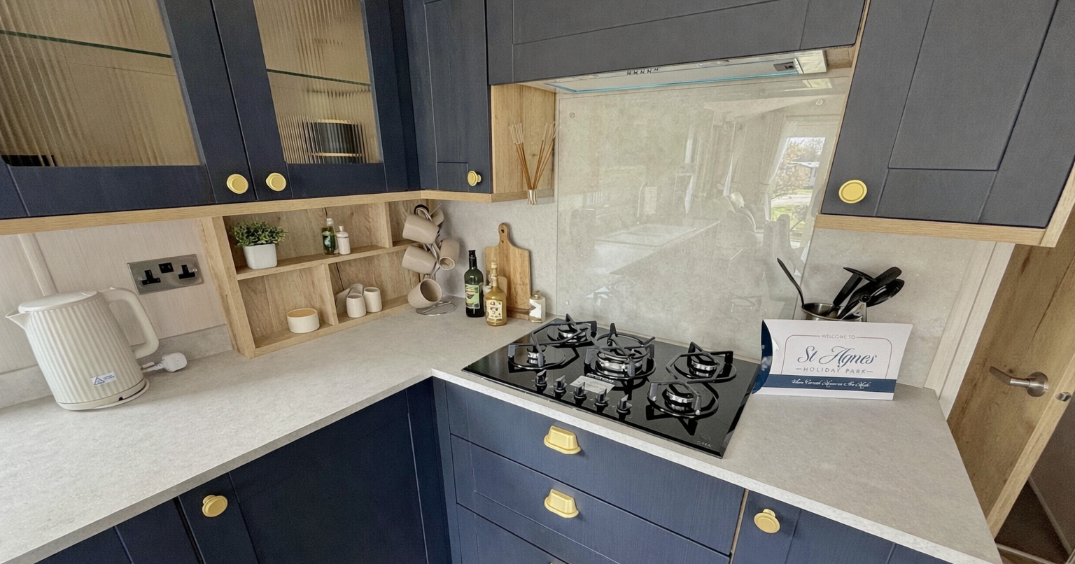 Modern kitchen with navy cabinets, a gas stove, and countertop accessories