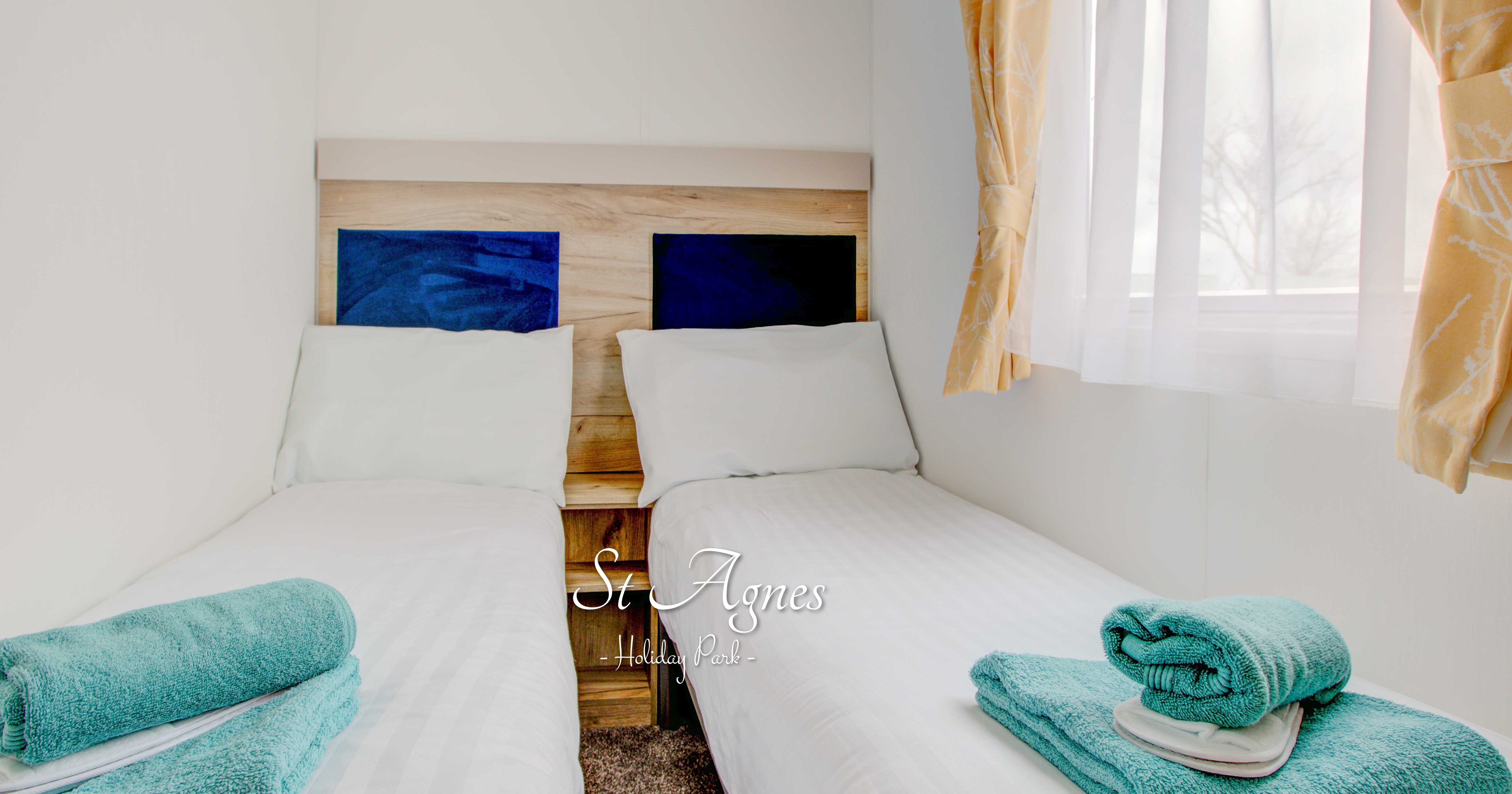 Twin beds with blue towels