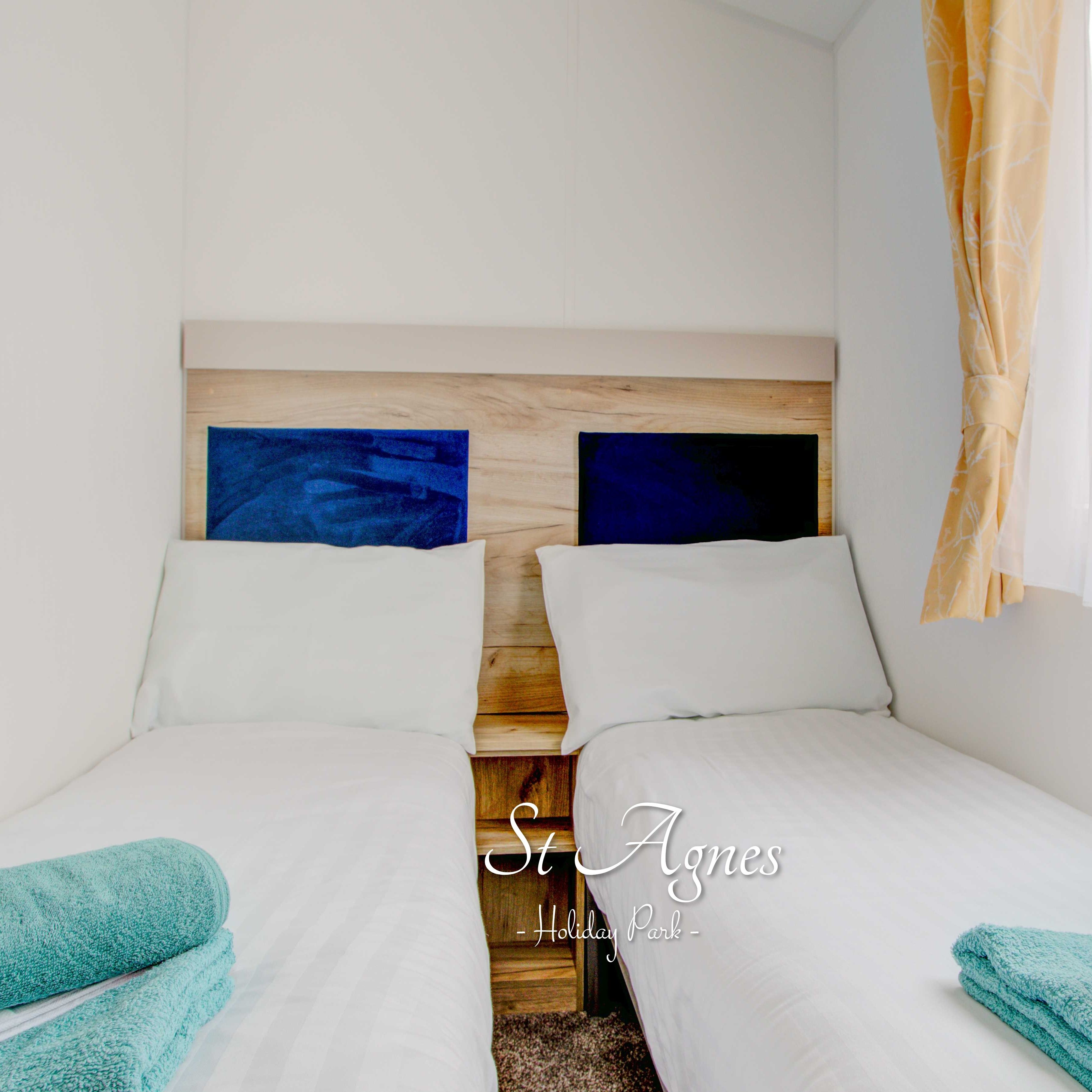 Twin beds with blue towels