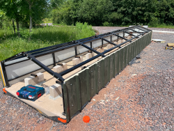 The side cladding sheets being placed on the ground level carriage shed.