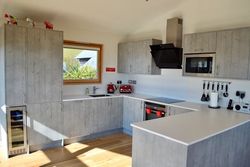 Modern kitchen with gray cabinets, white countertops, and stainless steel appliances.