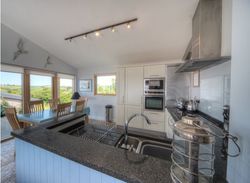 Modern kitchen and dining area with large windows and countryside views
