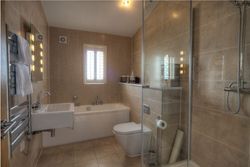 Modern bathroom with sink, toilet, bathtub, and glass shower enclosure.