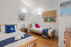 Modern twin bedroom with wooden beds, blue accents, and playful decor