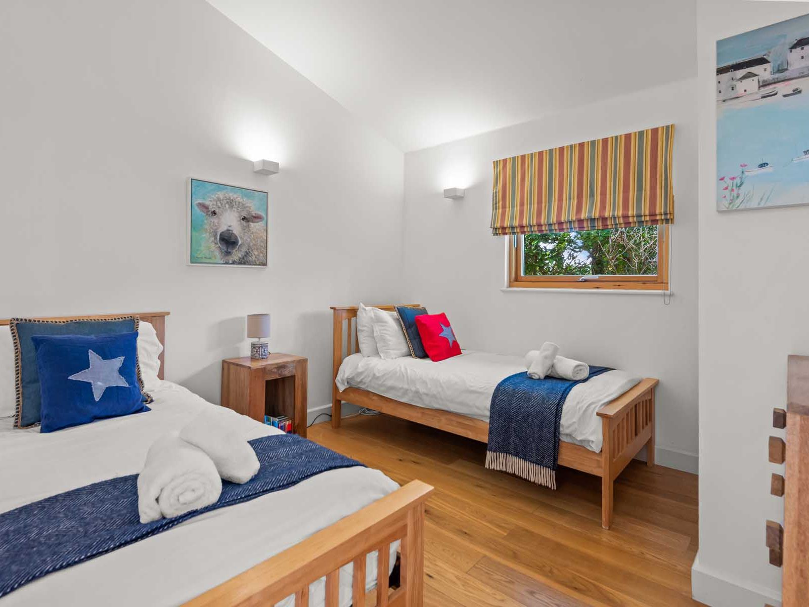 Modern twin bedroom with wooden beds, blue accents, and playful decor