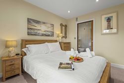 Cozy bedroom with a wooden bed, en-suite bathroom, bedside tables, and breakfast tray on the bed