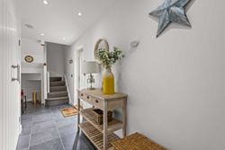 Modern hallway with wooden console table, stairs, and decorative items