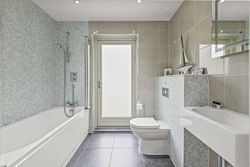 Modern bathroom with bathtub, toilet, washbasin, and decorative accessories