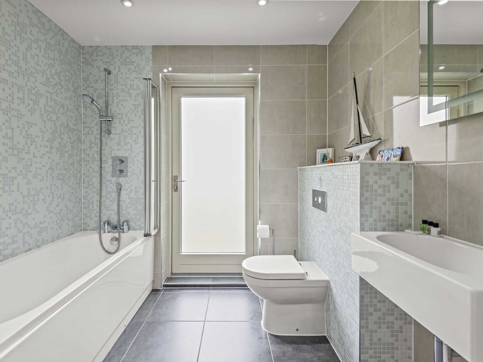 Modern bathroom with bathtub, toilet, washbasin, and decorative accessories